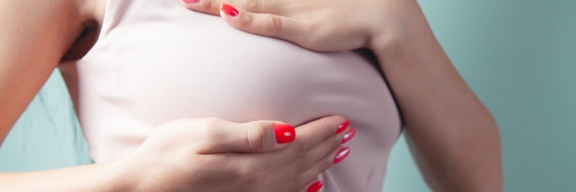 a woman with red nail polish holding her stomach